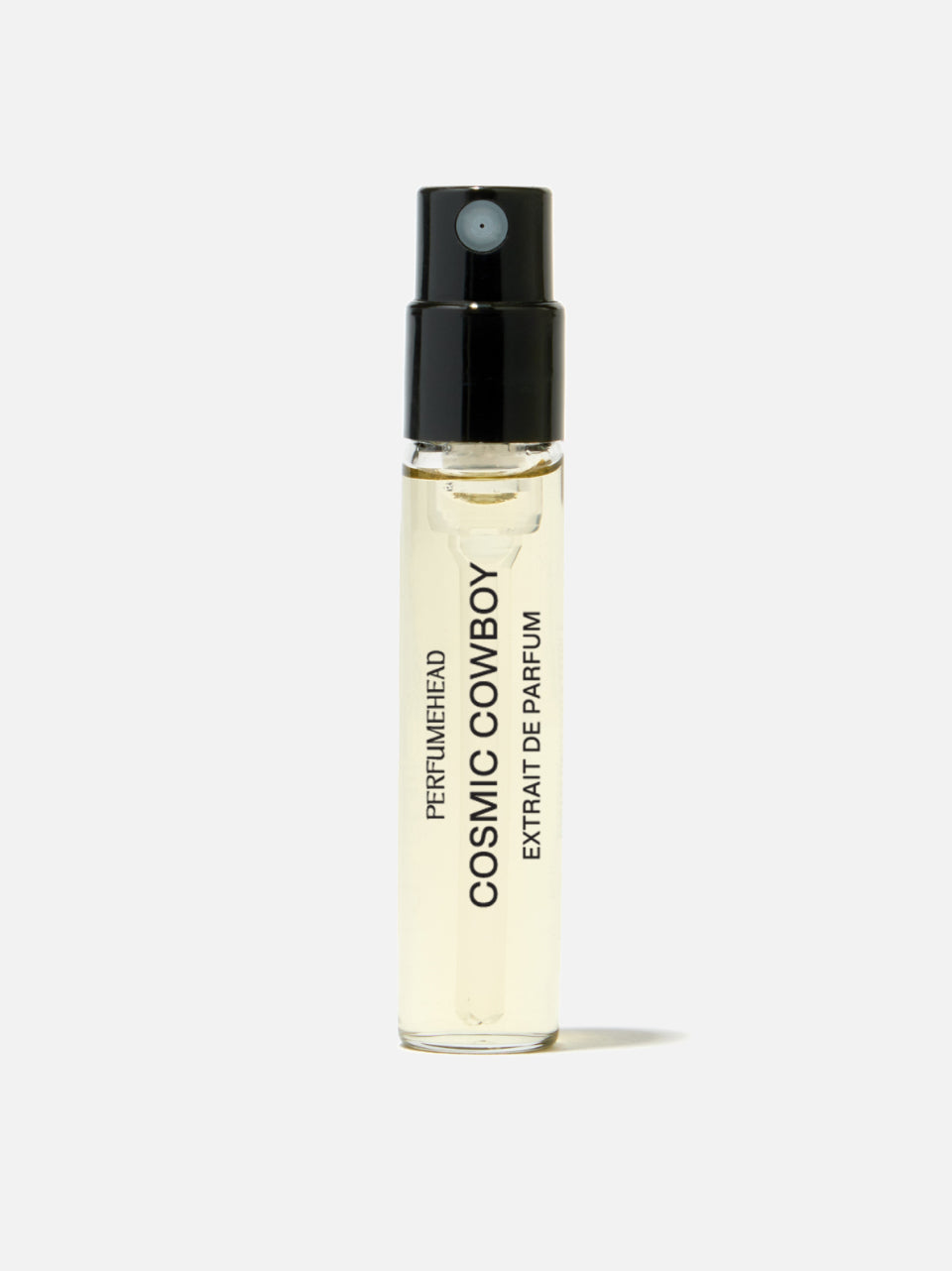 A clear glass perfume vial with pale yellow liquid, a black spray top, and black vertical text reading 'COSMIC COWBOY EXTRAIT DE PARFUM' on a light gray background.
