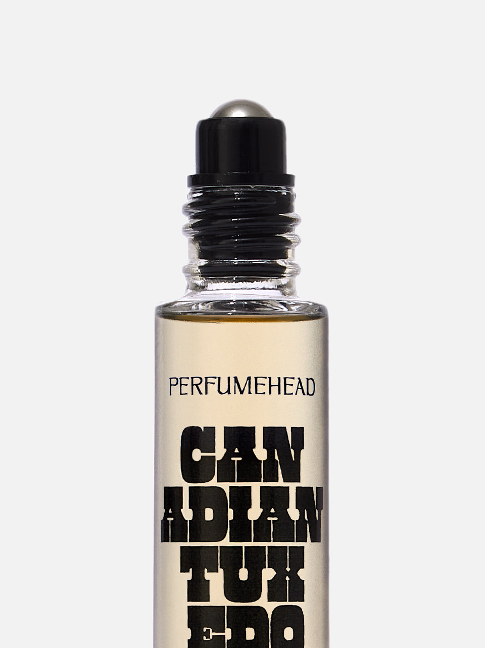 A clear glass perfume roller bottle with a black cap and silver roller ball, filled with a pale amber liquid. The bottle features text reading 'PERFUMEHEAD' and 'CANADIAN TUXEDO'.