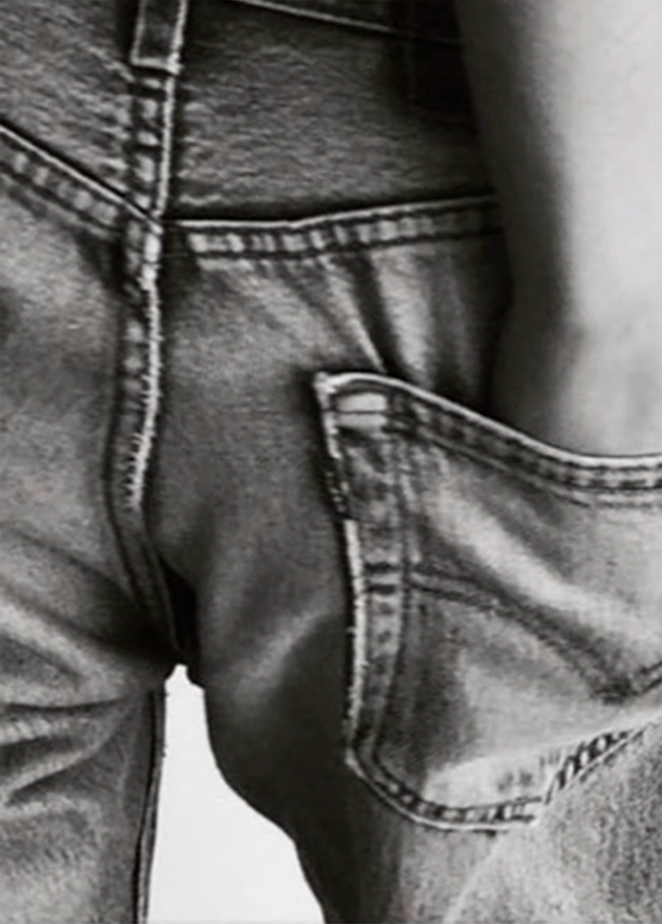 Close-up of a person wearing faded gray denim jeans, showing the back pocket and waistband area.