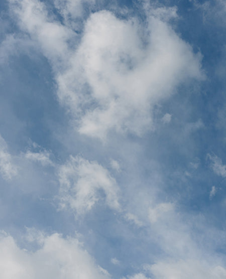 Blue sky with scattered white clouds.