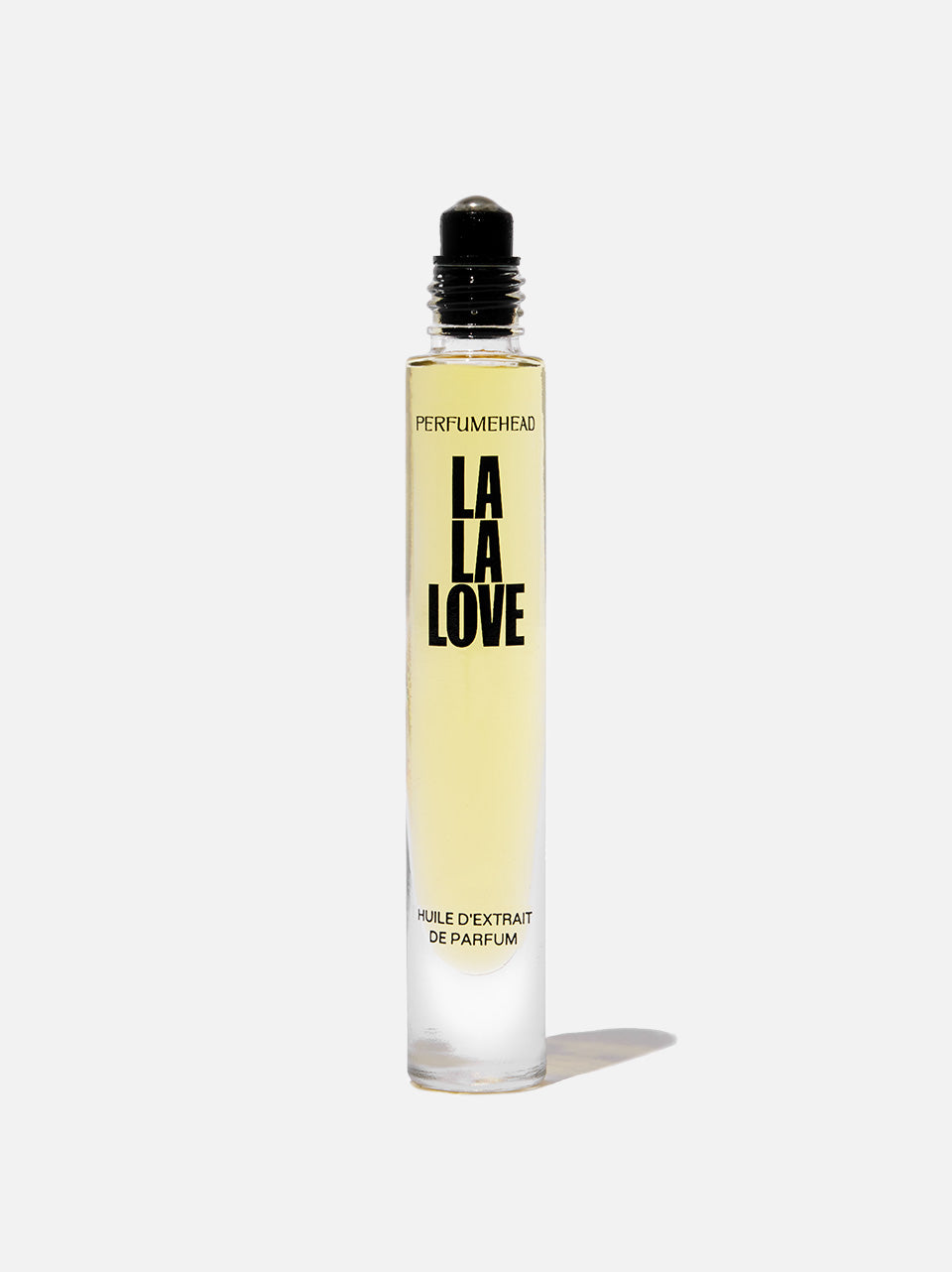 A clear glass rollerball perfume bottle with pale yellow liquid, featuring bold black text that reads 'LA LA LOVE', set against a white background with a soft shadow.