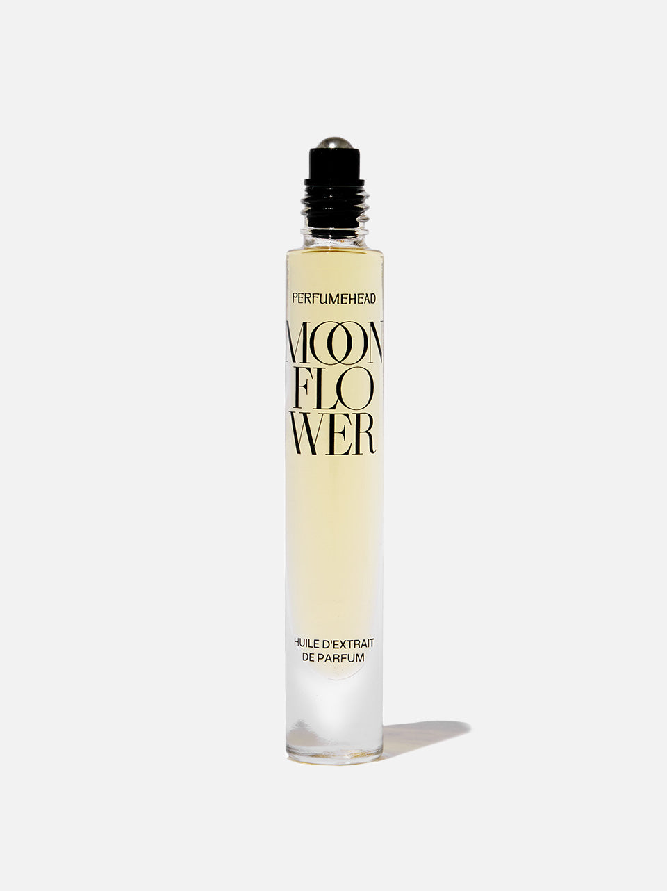 A clear glass rollerball perfume bottle with pale yellow liquid, featuring black text that reads 'PERFUMEDHEAD' and 'MOONFLOWER', set against a white background with a soft shadow.