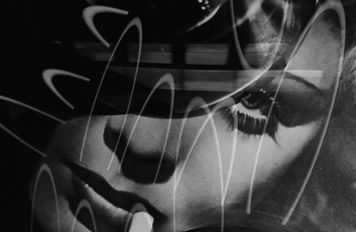 Black and white close-up artwork of a woman's face with layered white curved line overlays.