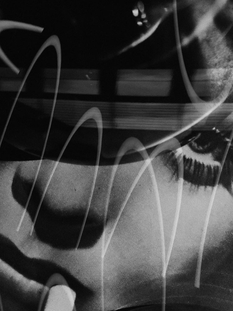 Black and white close-up artwork of a woman's face with layered white curved line overlays.