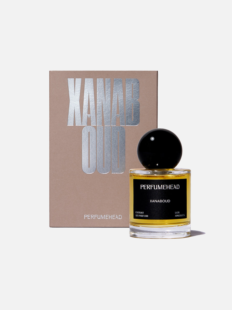 50ml bottle of Perfumehead XANABOUD in front of a beige box with metallic text 'XANABOUD'. 